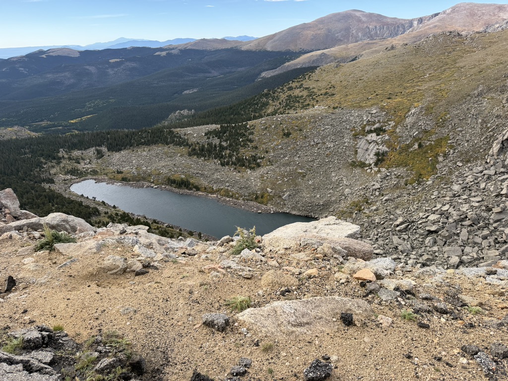 An alpine lake below rocky mountain slopes, photographed by Patricia Bukur